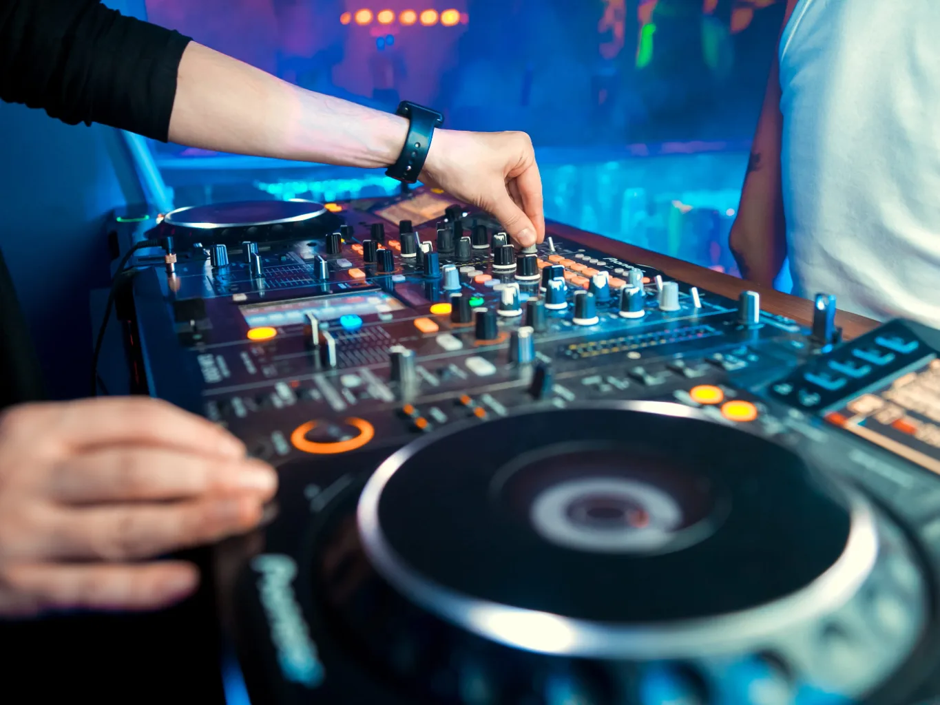 A dj working on a residential dj services for special events job — mid-task, hands, tools and the work itself in sharp focus, the rest of the space softly out of focus