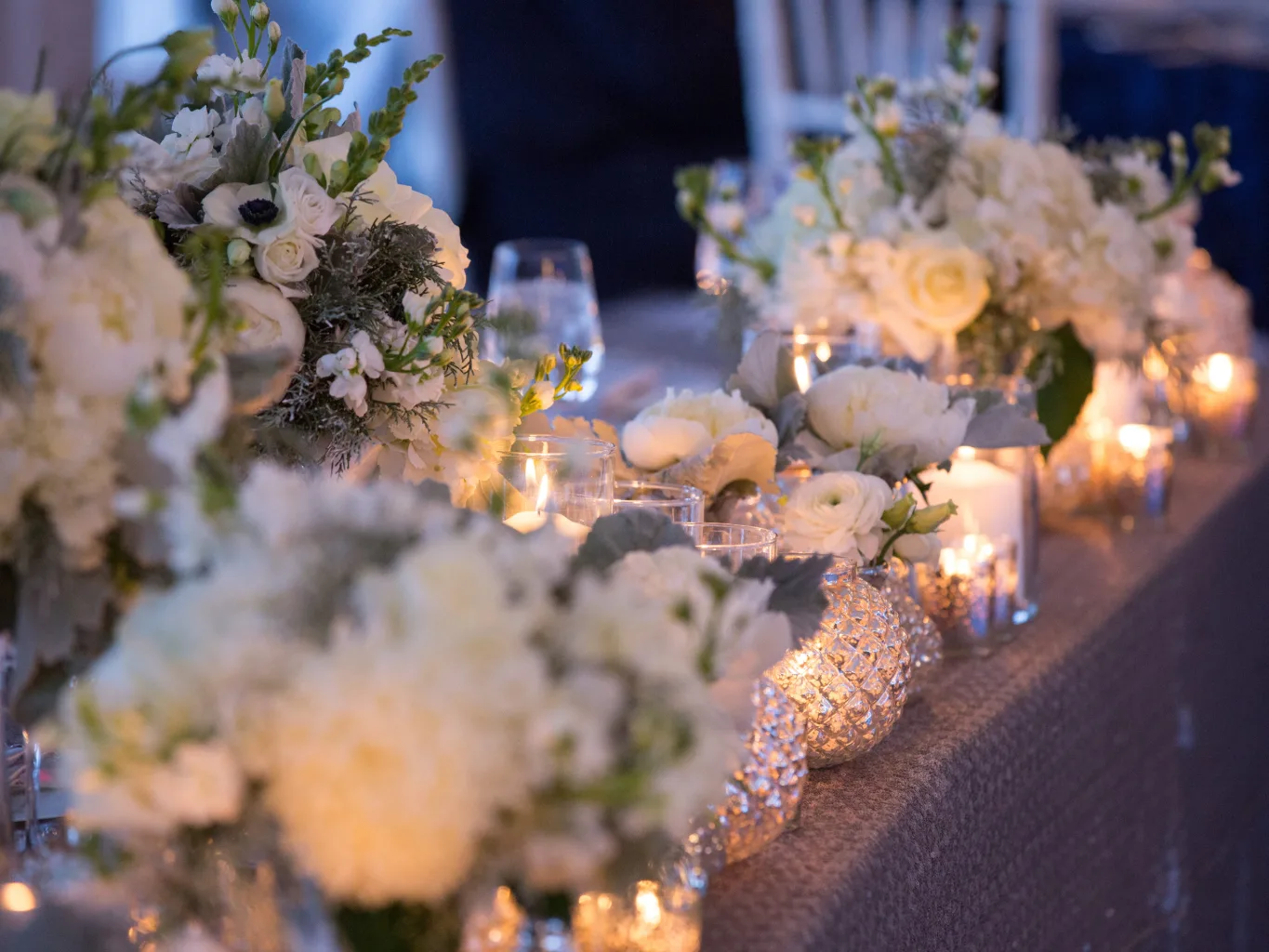 A dj working on a residential event design and décor job — mid-task, hands, tools and the work itself in sharp focus, the rest of the space softly out of focus